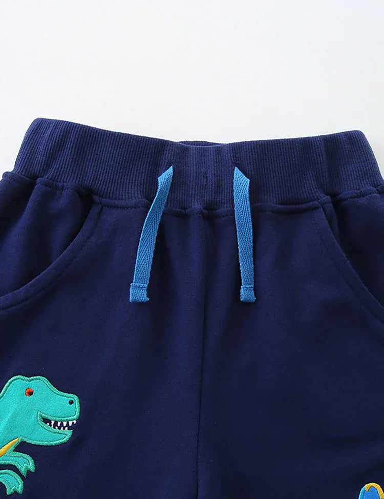 Pantaloncini con applicazioni di dinosauri dei cartoni animati